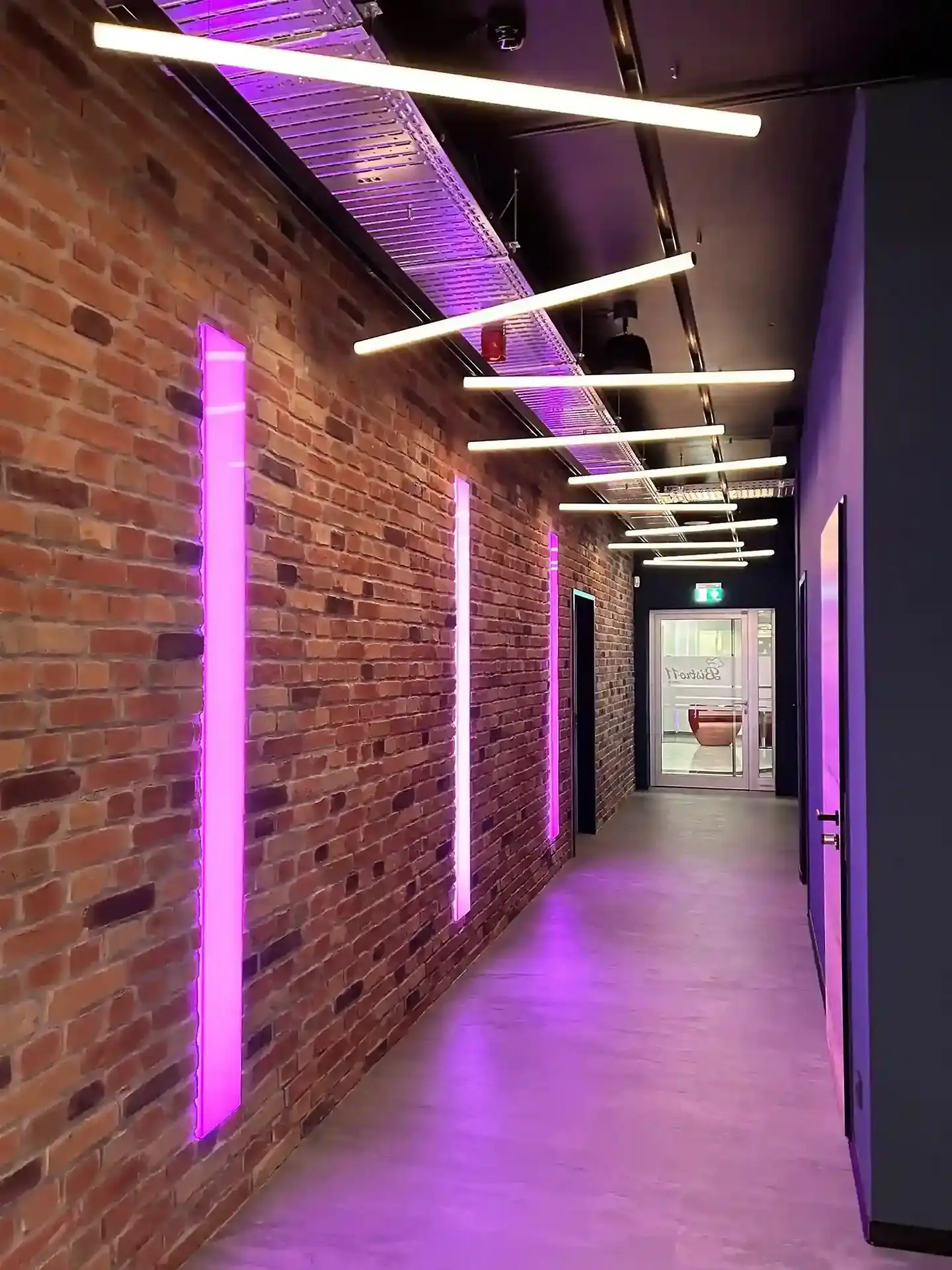 Moderner Flur mit Backsteinwand und violetten LED-Lichtleisten, Bürogebäude