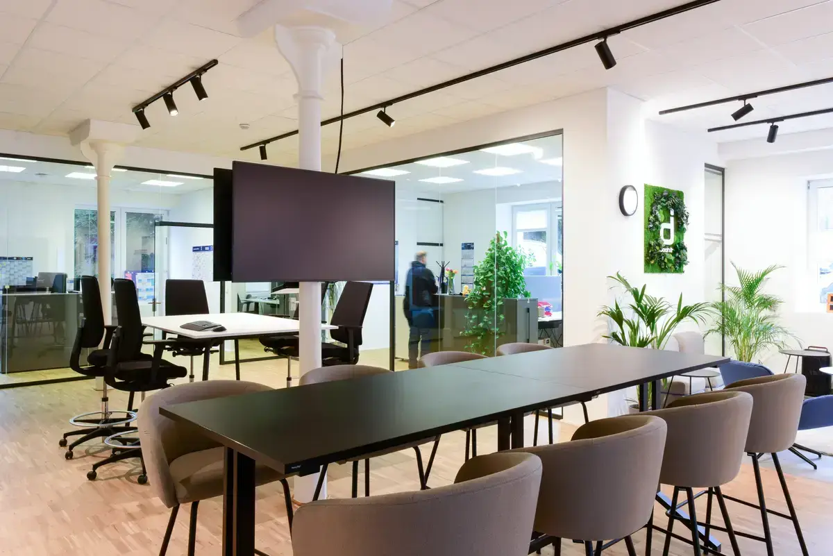 Moderner Konferenzraum im Büro mit großem Bildschirm, Tisch und Stühlen